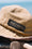 Beige bucket hat with 'Back 2 Basics' logo against a blurred natural background