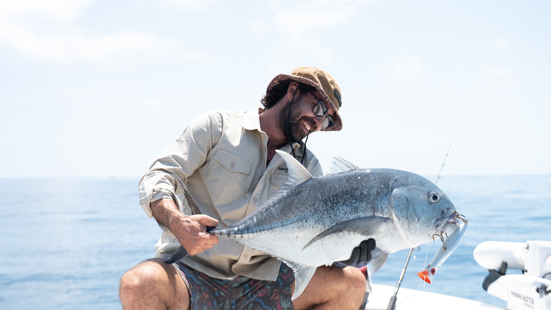 az from back 2 basics adventures holding a giant trevalley wearing a b2b adventures uv lightweight fishing shirt and boardshorts while on the great barrier reef